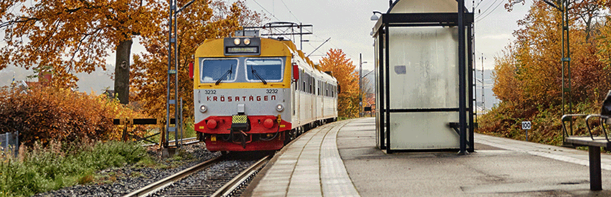 Bild på ett gulrött Krösatåg ståendes vid en station.