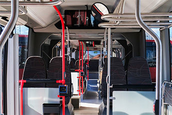 Interiören av en JLT-buss med säten i förgrunden.