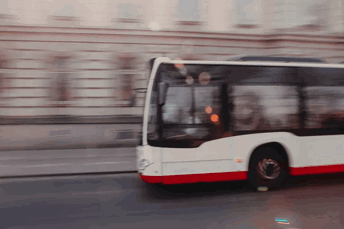 Buss kör förbi kameran hastigt, med en suddig bakgrund.
