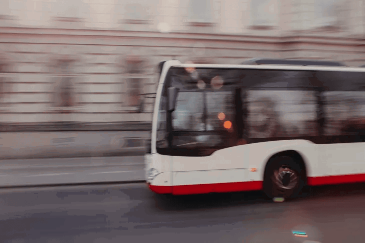Buss kör förbi kameran hastigt, med en suddig bakgrund.