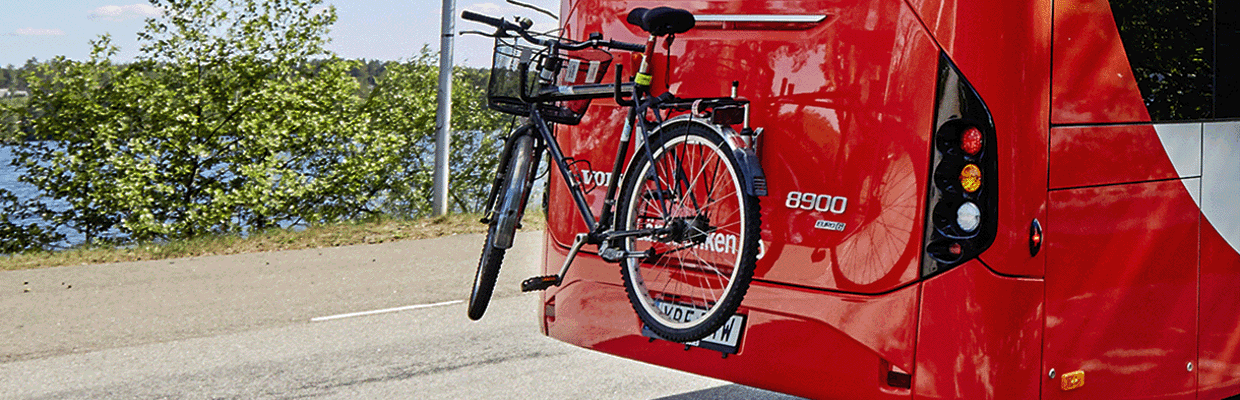 Cykel som är fäst på bakre delen av en buss.