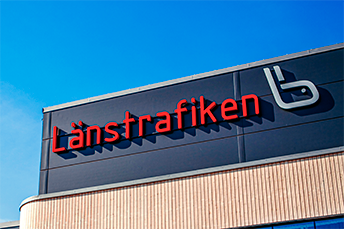 Bild på en JLT-logotyp som sitter på fasaden av en byggnad.