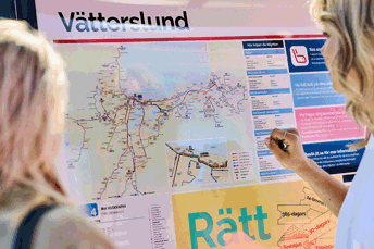 Två tjejer står framför en karta med busslinjer i Jönköping.