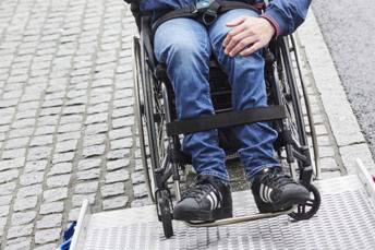 Närbild på en en person som sitter i rullstols ben.