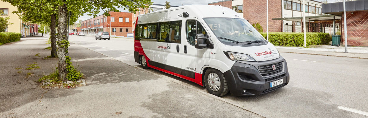 Bild på en serviceresebil som står parkerad framför en röd tegelbyggnad.